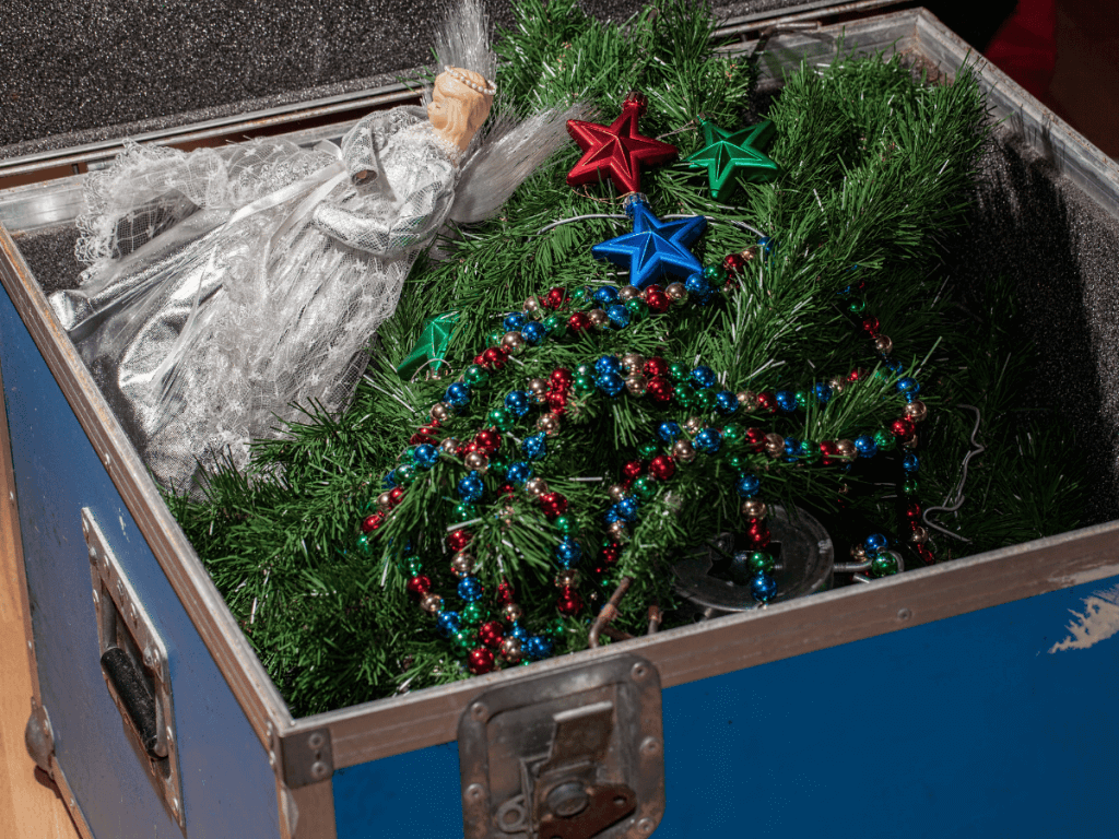 an open blue box contains festive garlands an christmas decorations.